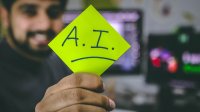 Business professional holding sticky note with Artificial Intelligence "AI" written on it