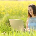 Young woman working outside on laptop