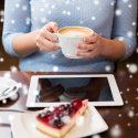 Woman with coffee at laptop with snow falling